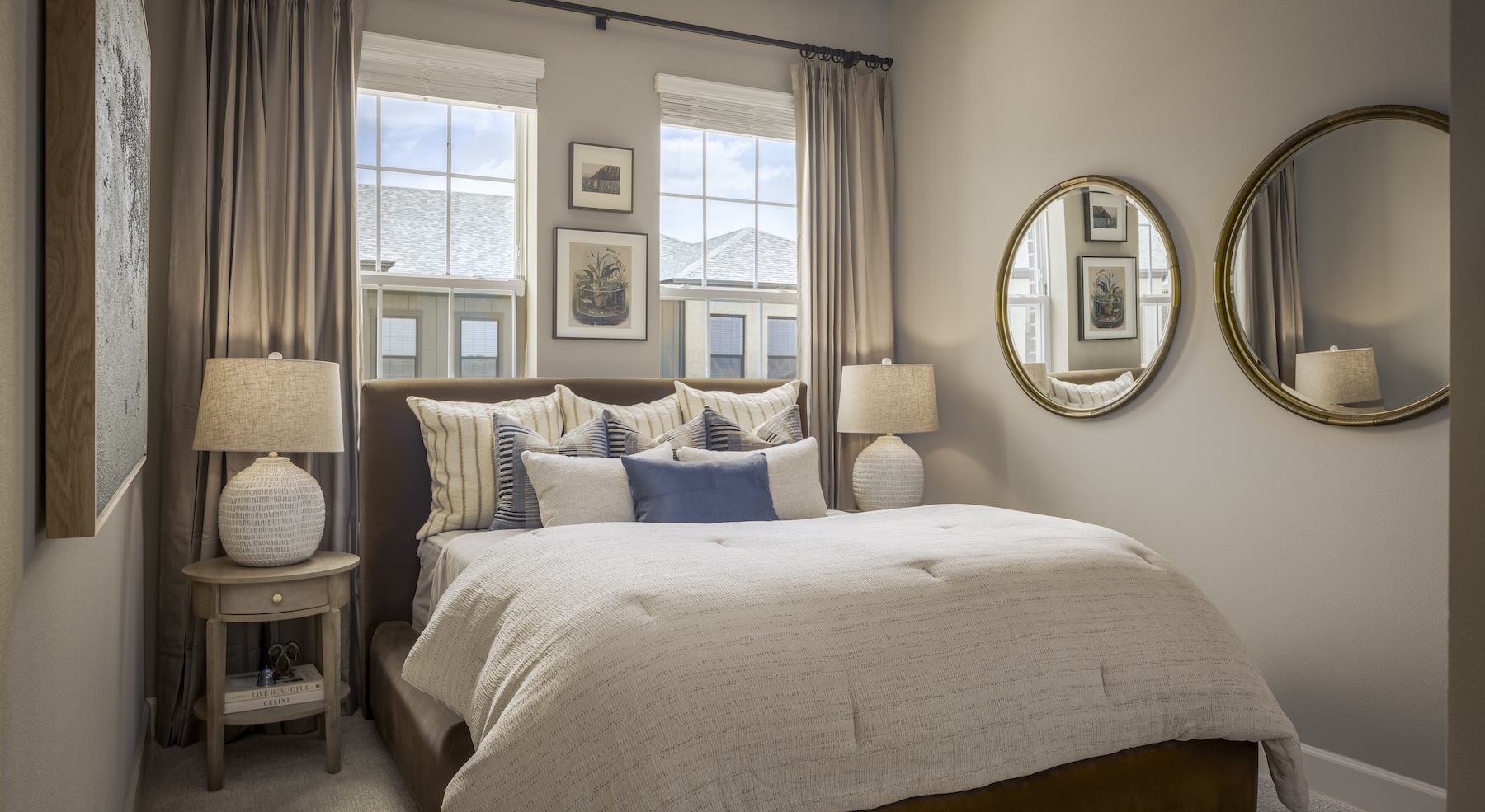 bedroom with bed lamps mirrors and windows