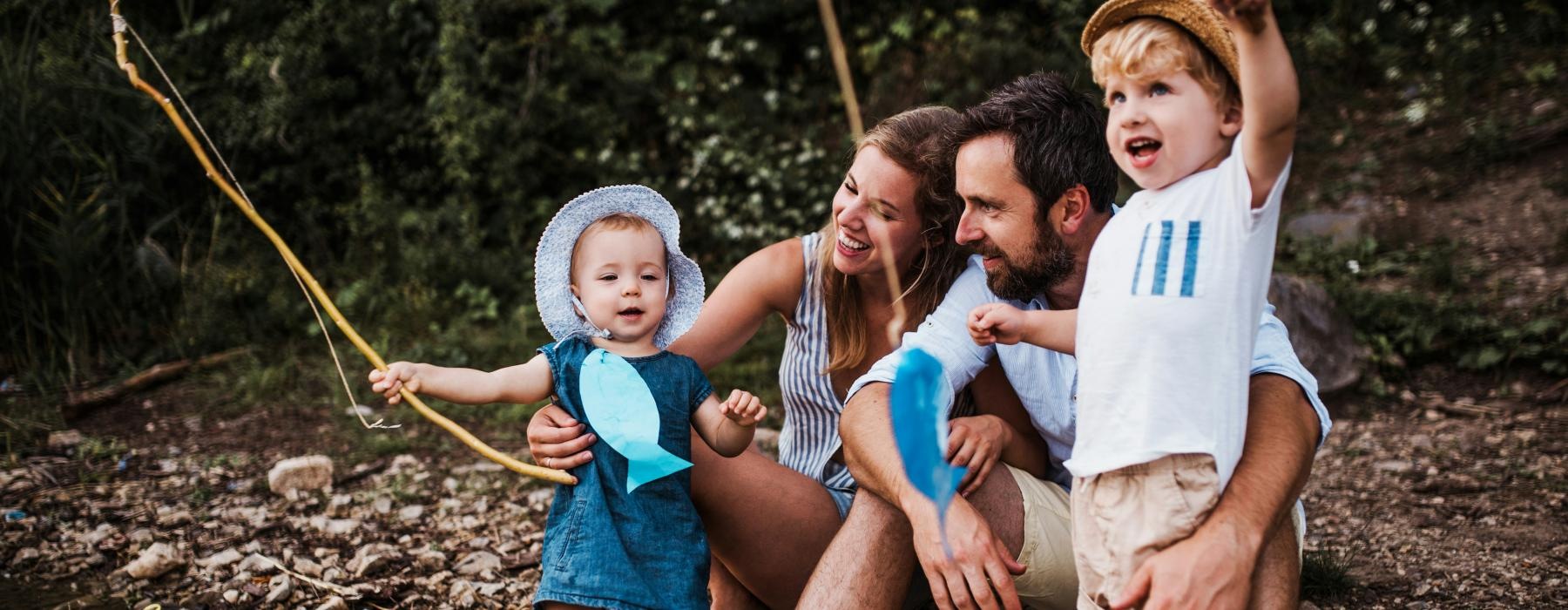 a young family fishing and smiling