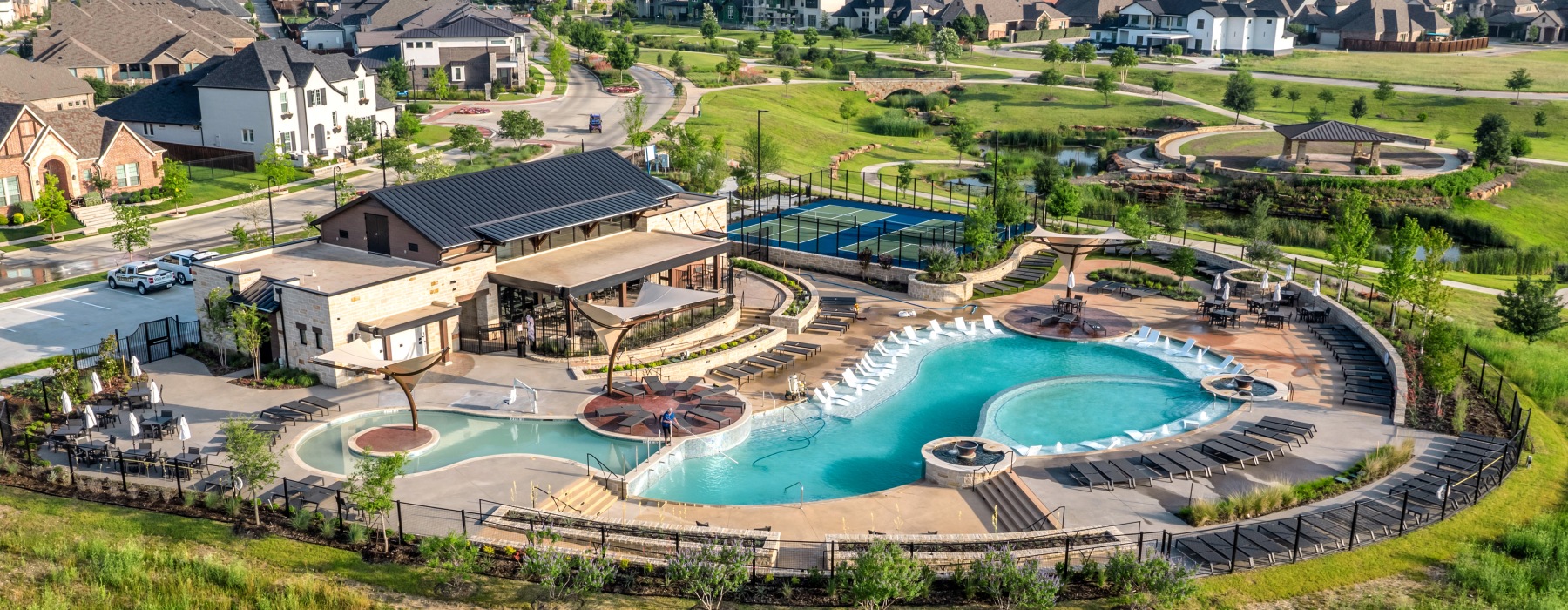 a high angle view of a townhome community with resort-style pools beside lake Viridian 