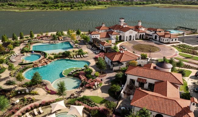 a high angle view of a resort with pools and body of water