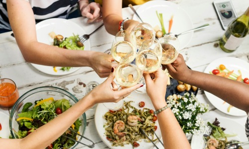 group of friends surrounding a table with food on it