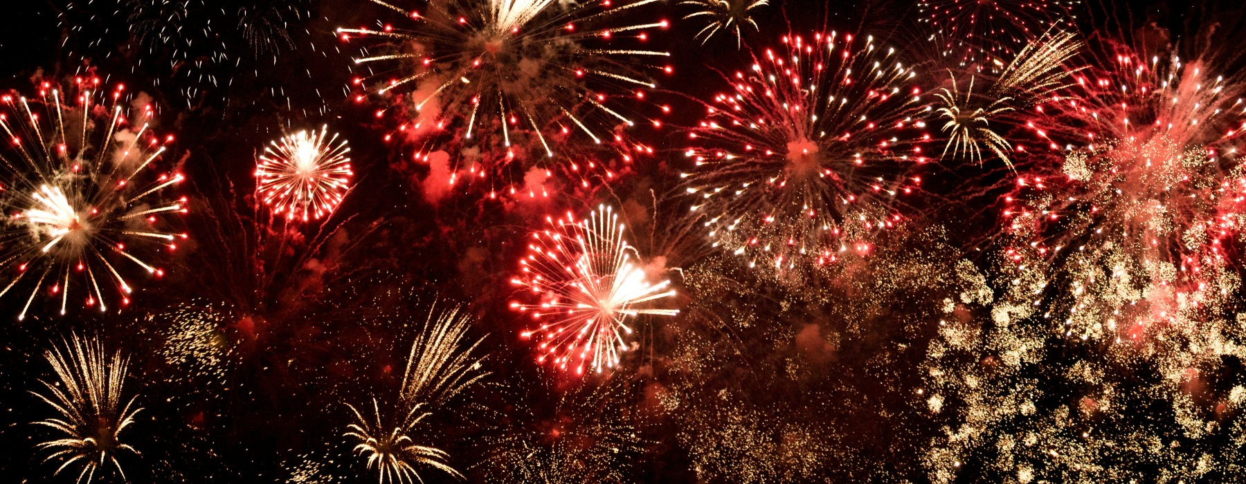 yellow and red fireworks in the night sky