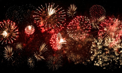yellow and red fireworks in the night sky